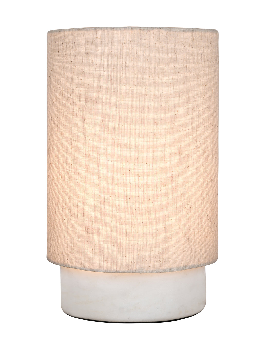 Table lamp switched on, showing a warm glow through its cream linen shade above the white marble base.