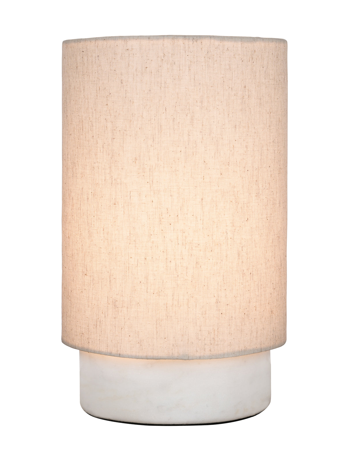 Table lamp switched on, showing a warm glow through its cream linen shade above the white marble base.