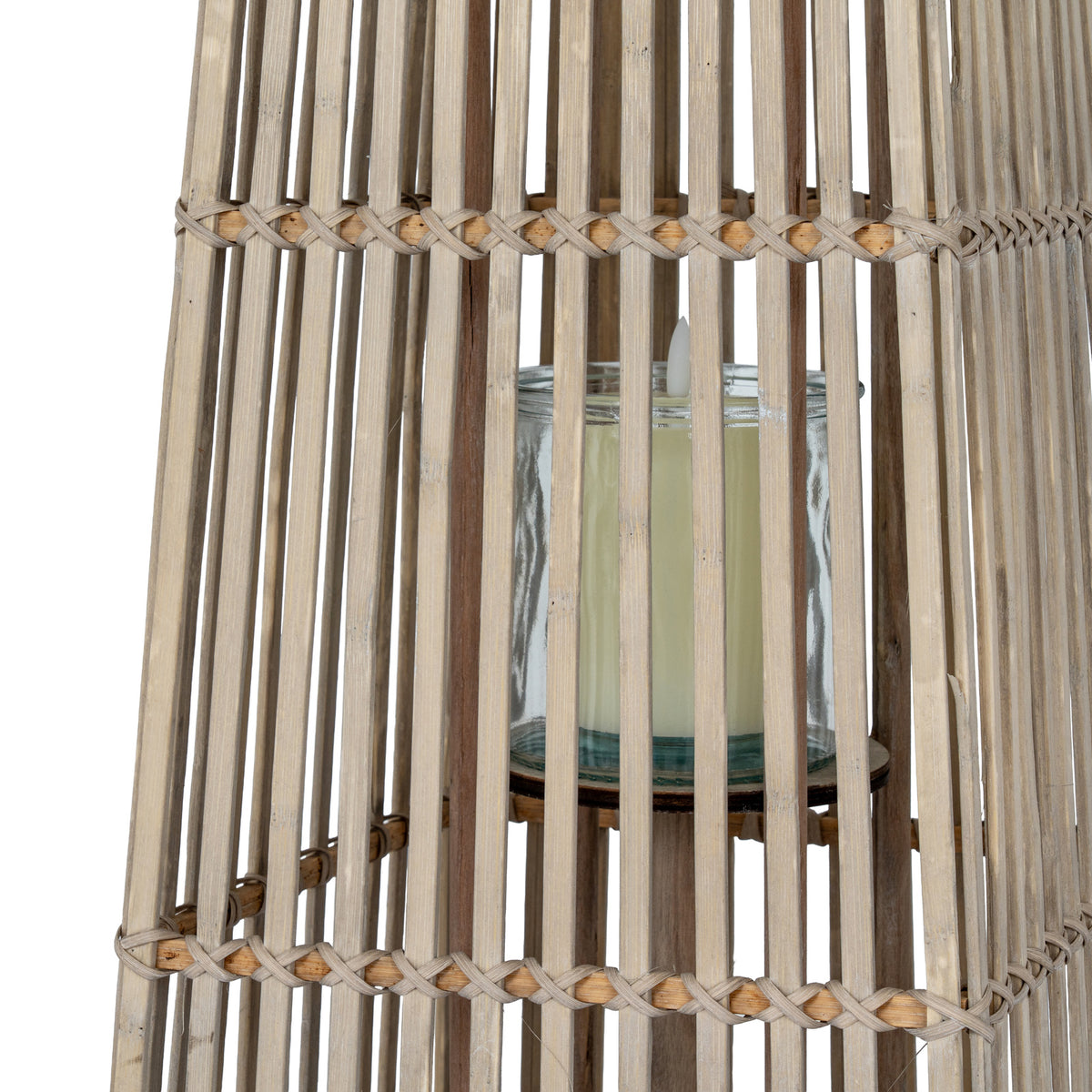 Close-up through the lantern's slats showing the transparent cylindrical holder, a pale candle and crossed bindings around the section joins.