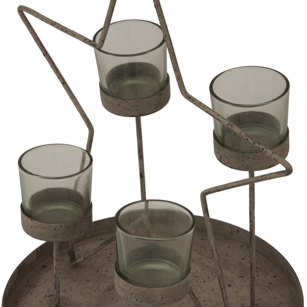 Angled close-up of the four grey-green votive cups, their round supports and the speckled, weathered-looking star outline above the raised tray.