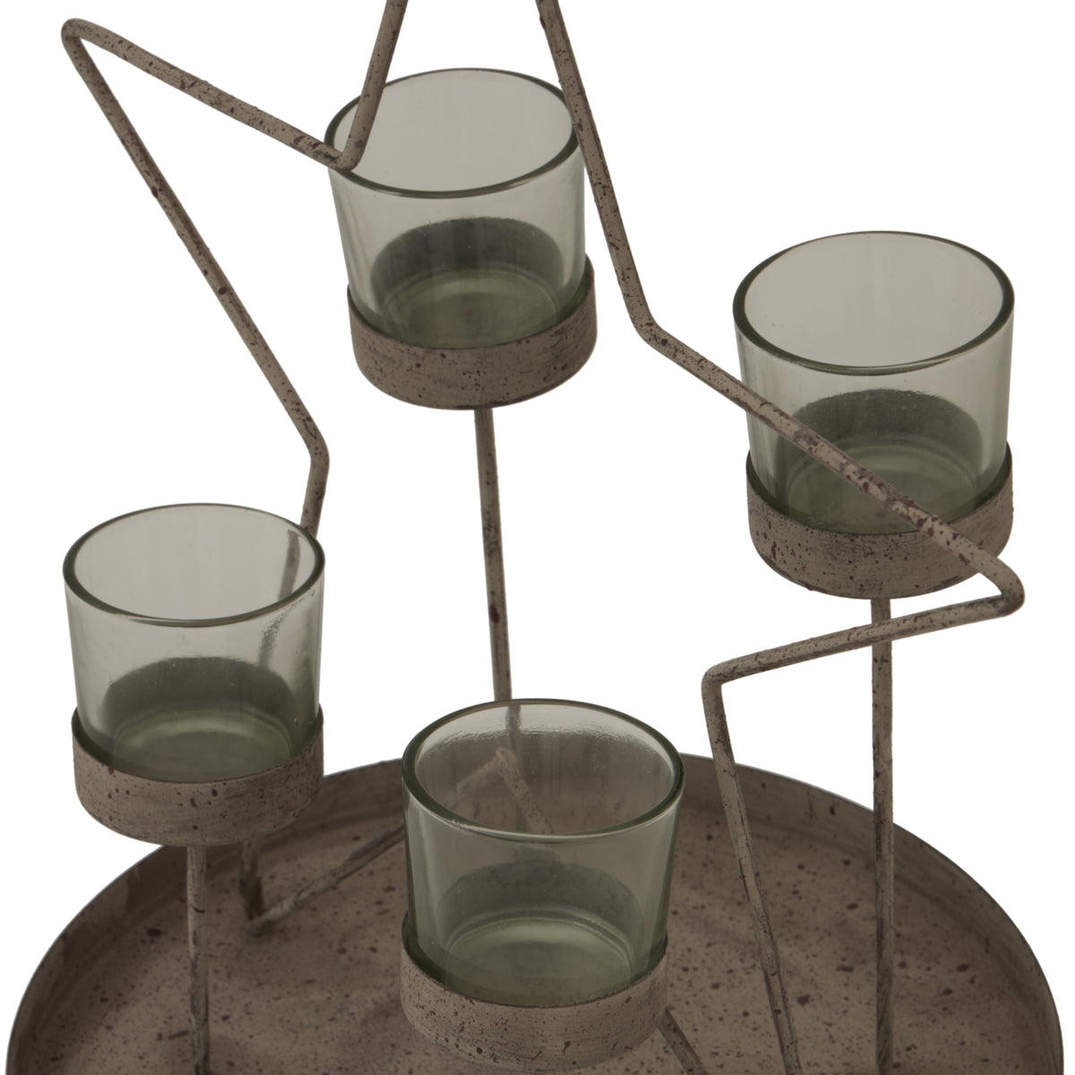 Angled close-up of the four grey-green votive cups, their round supports and the speckled, weathered-looking star outline above the raised tray.