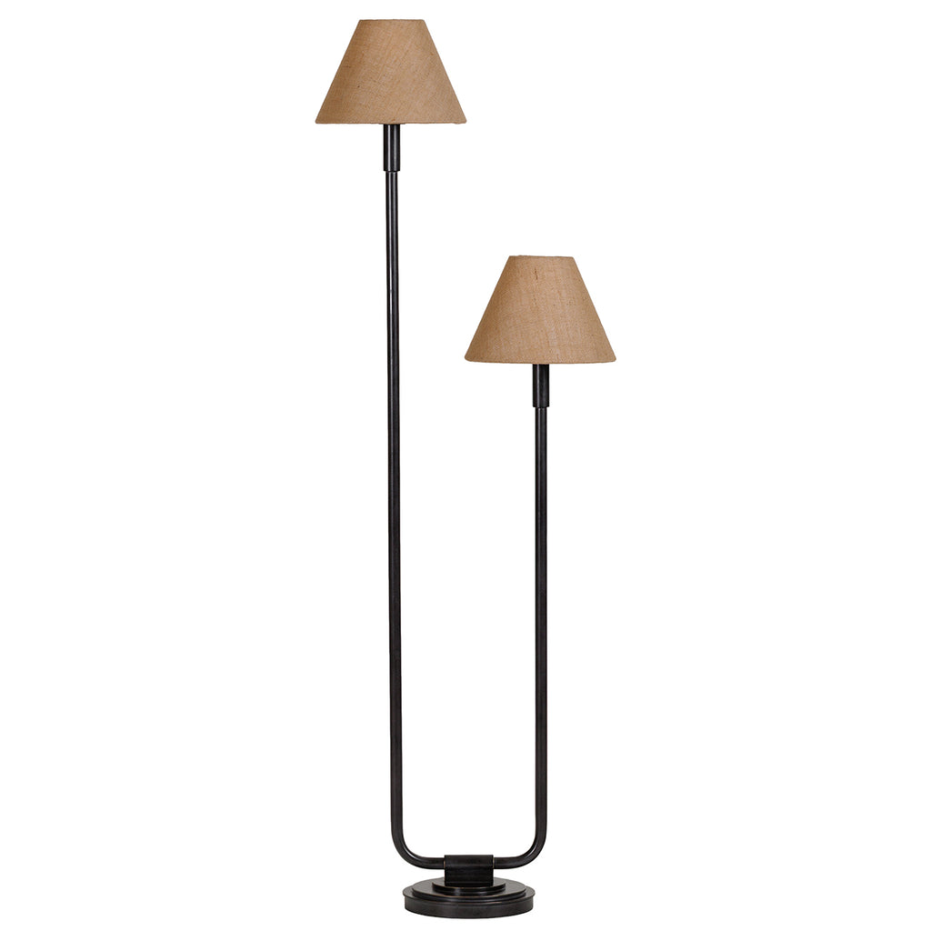 Twin floor lamp with two unlit natural fabric shades at different heights, a dark U-shaped frame and tiered circular base.