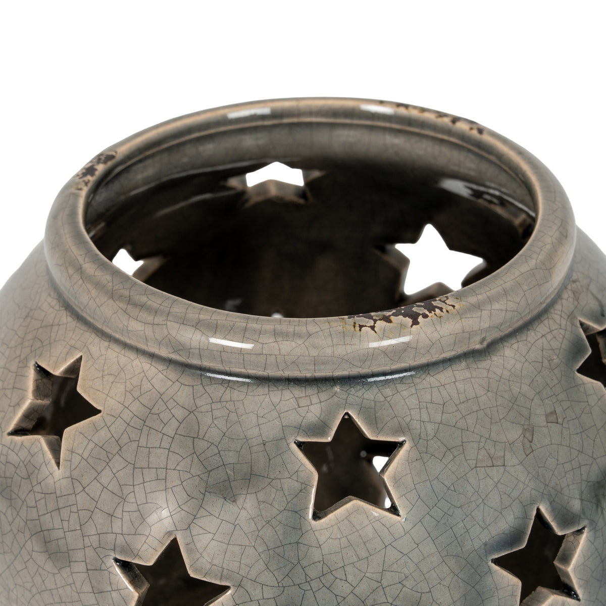 Close view into the lantern's open top, showing the rolled rim with brown distressed markings and star openings below.