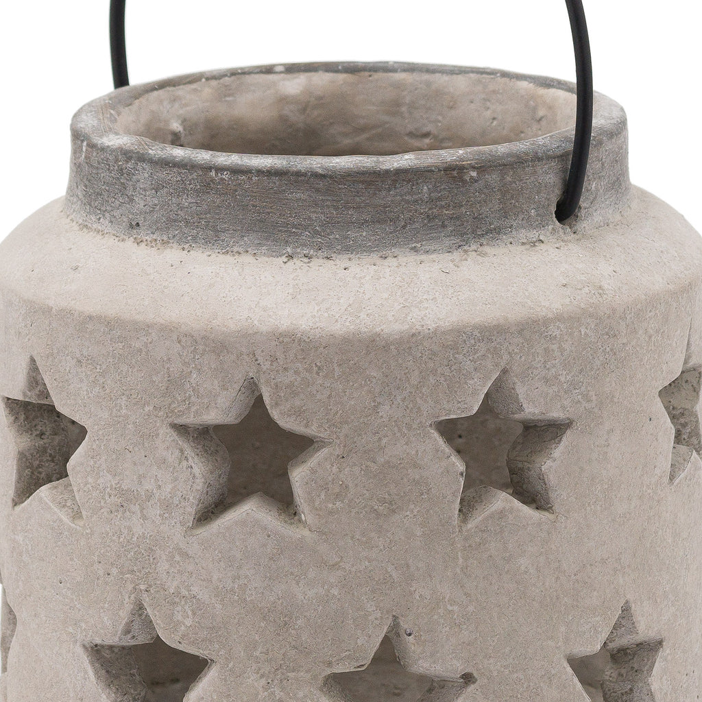 Close-up of the lantern's open neck, darker grey rim and star-shaped openings in the textured pale surface, with the sides of the black handle visible.