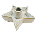Cream star-shaped candle holder viewed at an angle, with raised tray edges, a central cylindrical socket and warm brown rim detailing.