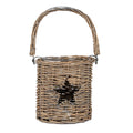Brown cylindrical woven lantern on a white background, with a star opening, clear inner vessel and tall arch handle attached by rings.