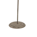 Detail of the ornament's slender stem and round base, showing a mottled grey-brown finish and scattered reddish marks.