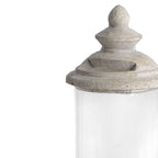 Close-up of the fitted tiered lid, showing its rounded finial, openings and textured off-white surface above the transparent cylinder.