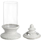 Candle holder with a clear cylindrical body on an off-white stepped pedestal, shown with the separate finial-topped lid beside it.