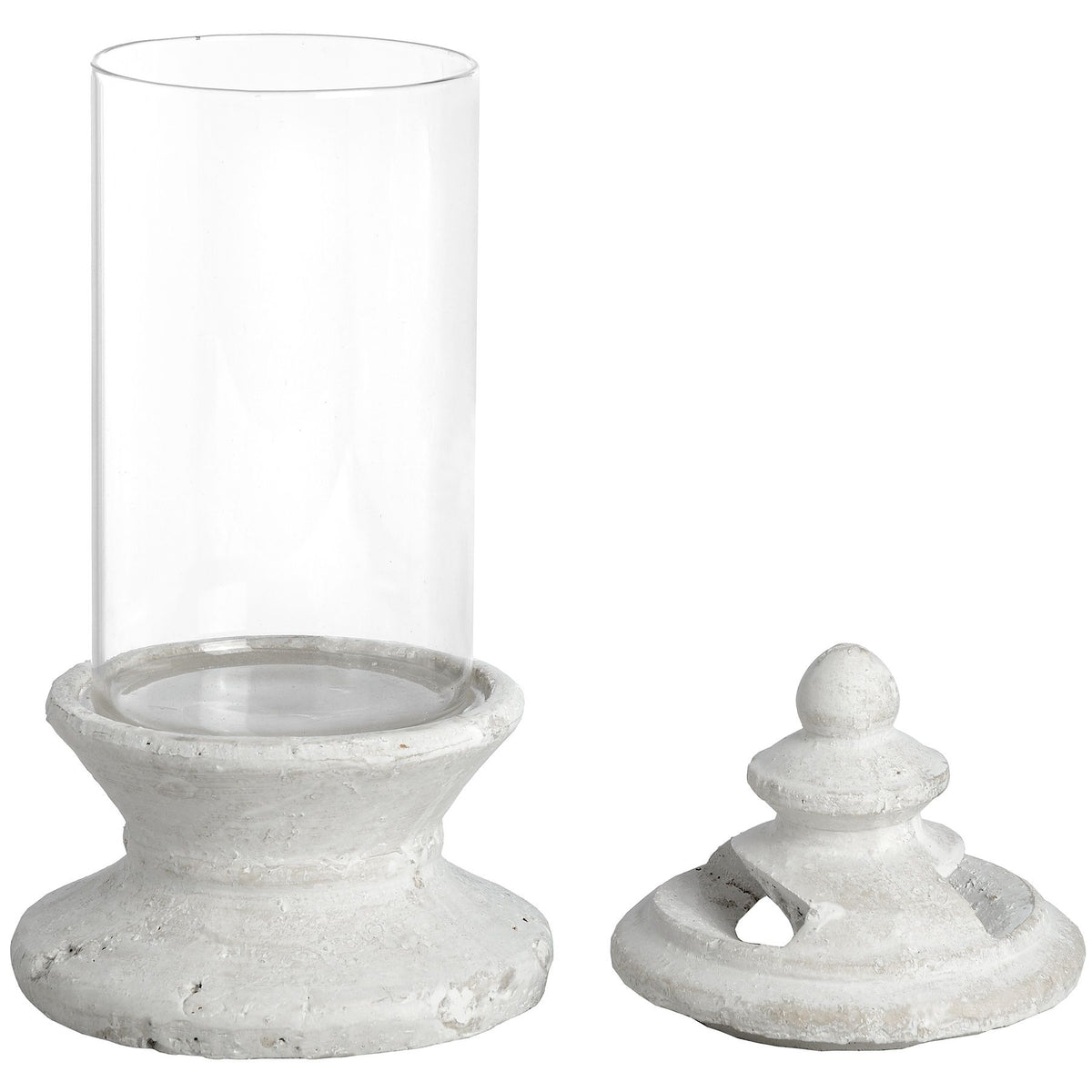 Candle holder with a clear cylindrical body on an off-white stepped pedestal, shown with the separate finial-topped lid beside it.