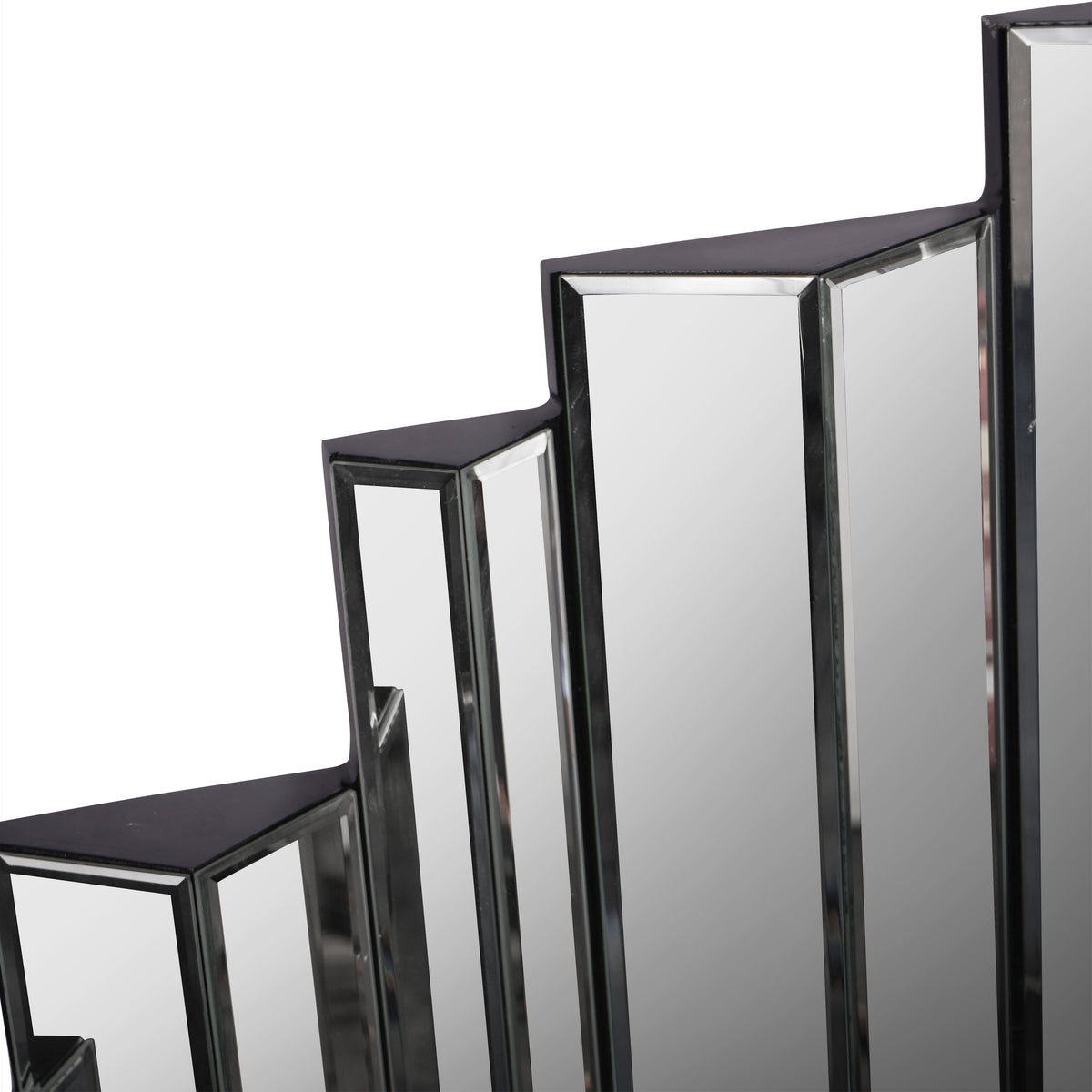 Detail of the mirror's stepped upper edge, showing adjacent bevelled panels and their angled faces.