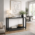 Black console table beneath framed line art, styled with a lamp, books, a white sculpture and a leafy vase, with books and a woven basket on the lower shelf.