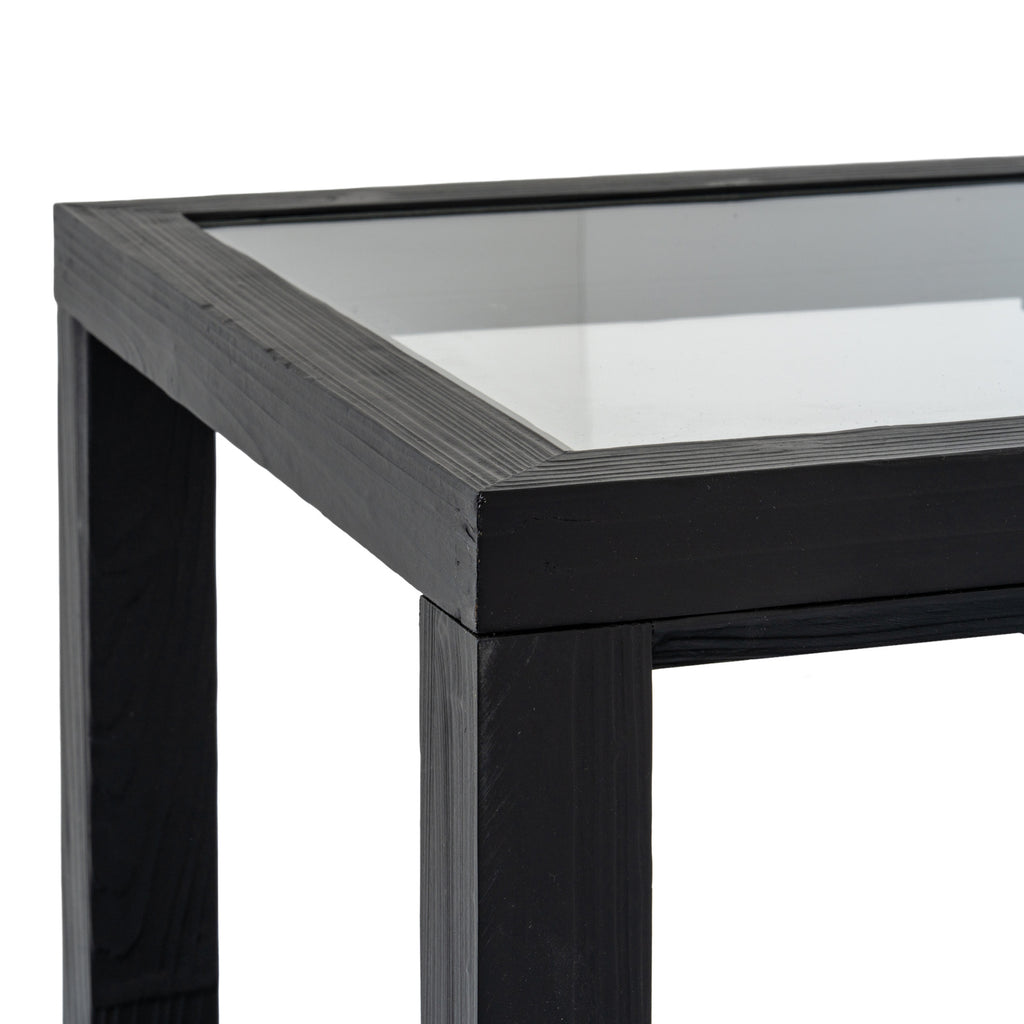 Detail of the reflective inset top bordered by a textured black frame at the table corner.