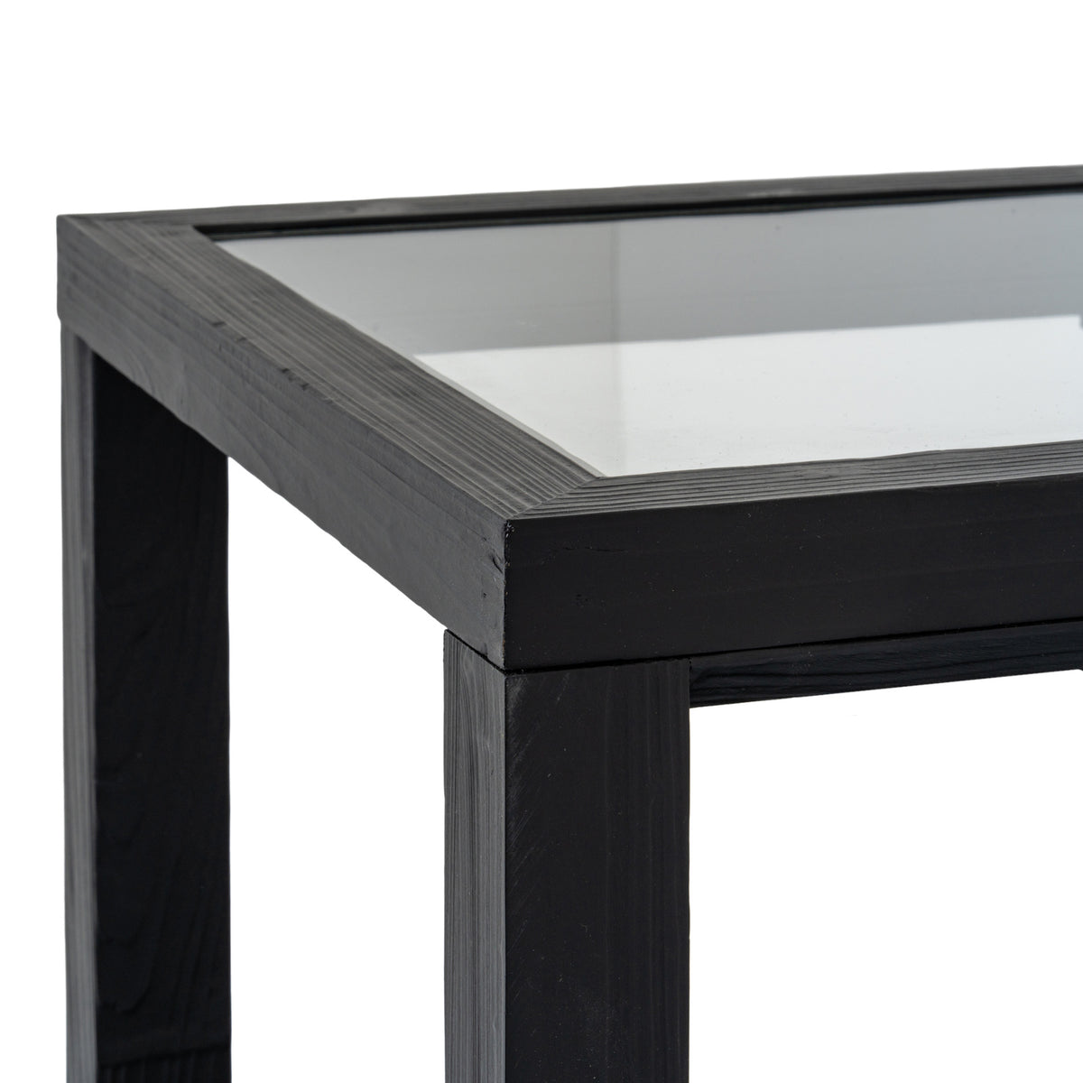 Detail of the reflective inset top bordered by a textured black frame at the table corner.