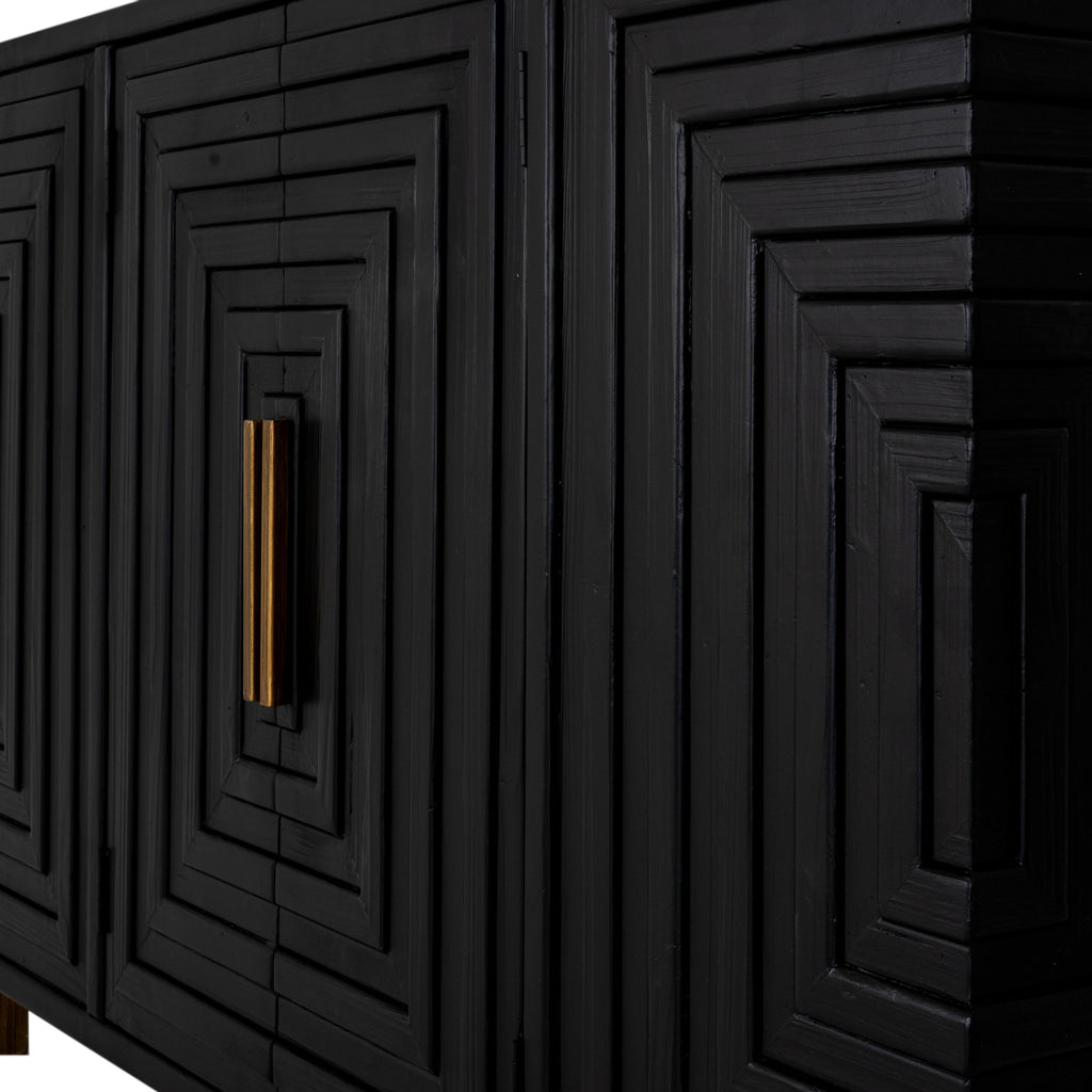 Close-up of the sideboard's black stepped relief and surface grain, with slim brass-toned handles beside the central door seam.