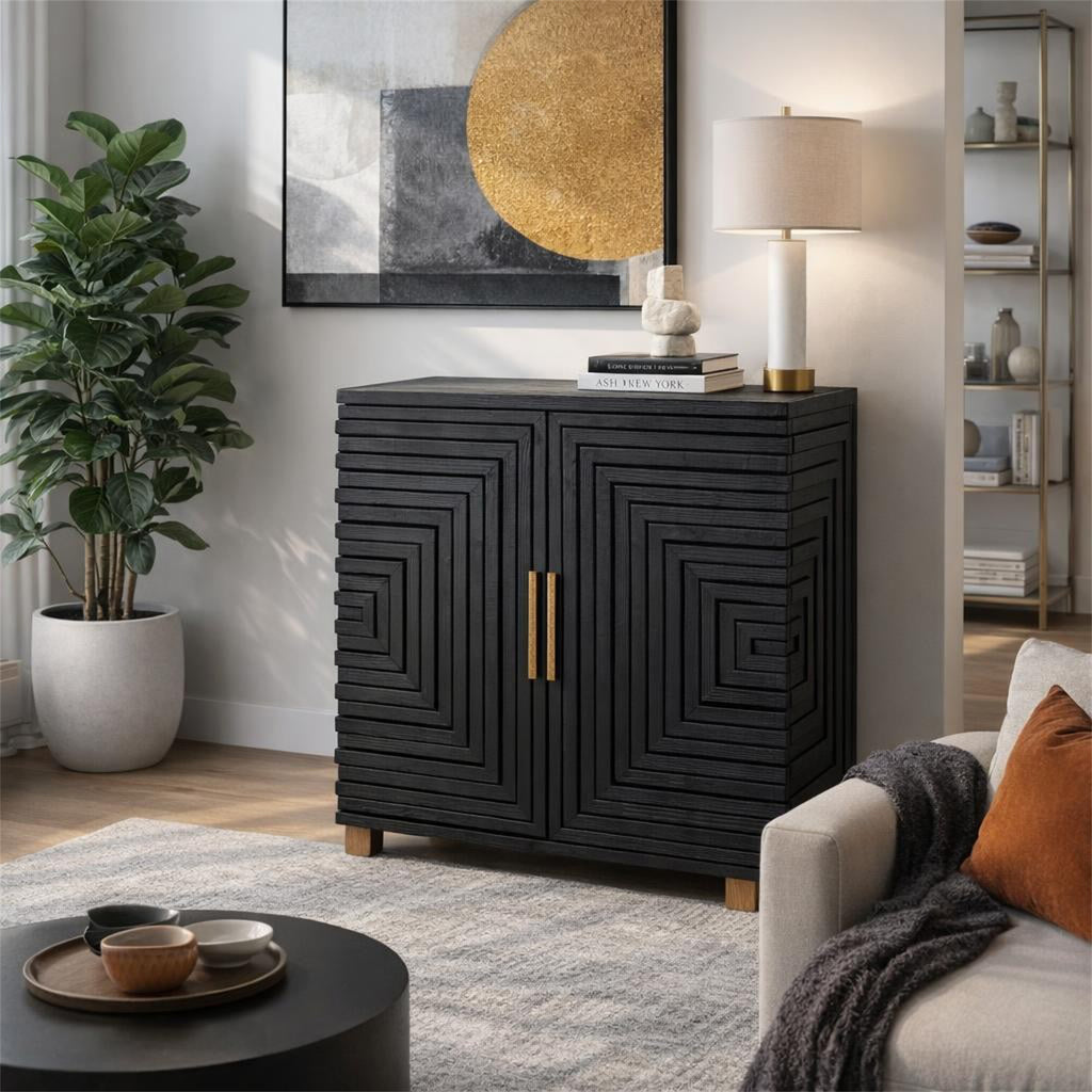 Black stepped-pattern sideboard styled beneath abstract artwork with books, a sculptural ornament and a table lamp, beside a plant and pale sofa.