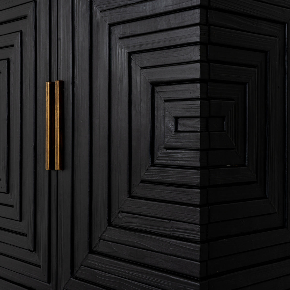 Close-up of the gold-toned bar handles and textured black strips forming stepped rectangles across the sideboard front and corner.