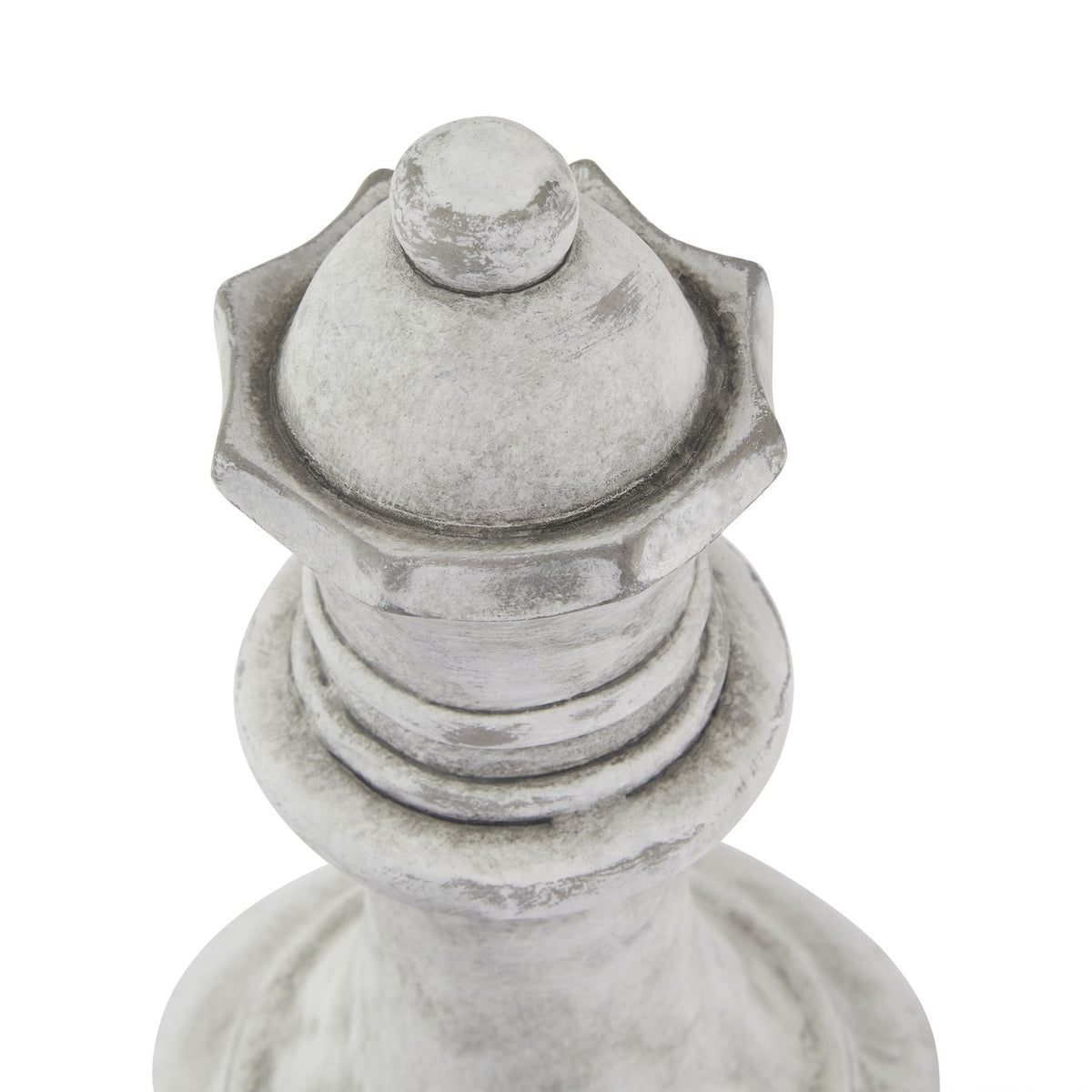 Close-up from above of the queen ornament's rounded crown and raised surrounding edge, showing darker weathered accents and the rings below.