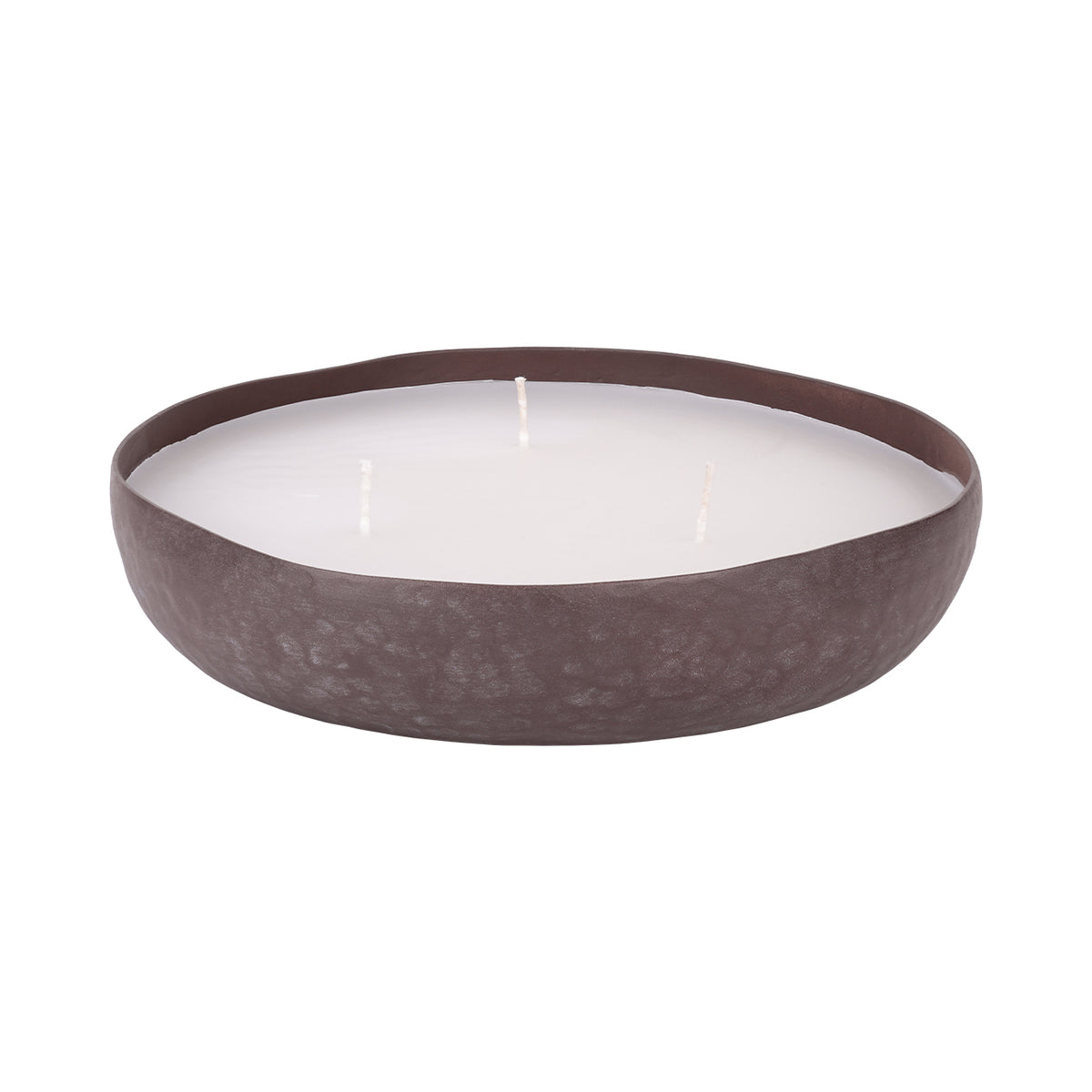 Angled view of the shallow brown bowl candle, showing white wax and three wicks within a mottled, hammered vessel.