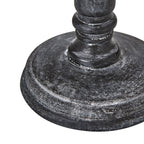 Close-up of the lamp's broad circular foot and lower column, with pale highlights across the dark textured finish.