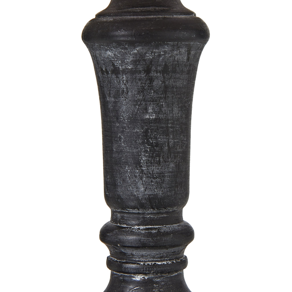 Close-up of the dark lamp column showing pale rubbed marks across its tapered centre and rounded collars.