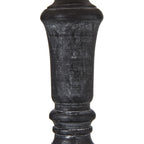 Close-up of the dark lamp column showing pale rubbed marks across its tapered centre and rounded collars.