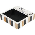 Angled view of a black, white and brown striped tray with a dark interior and four white dice in a narrow compartment.