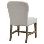 Rear three-quarter view of the dining chair, with round studs outlining the pale grey back and brown wood-grain detailing beneath the seat.