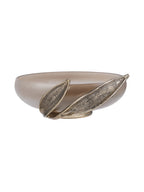 Side view showing the shallow glass bowl behind two elongated ribbed leaves of different lengths.