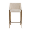 Front view of the Tall Back Counter Stool with textured oatmeal upholstery, a tall back with curved sides, antique-brass-finish legs and a horizontal footrest.