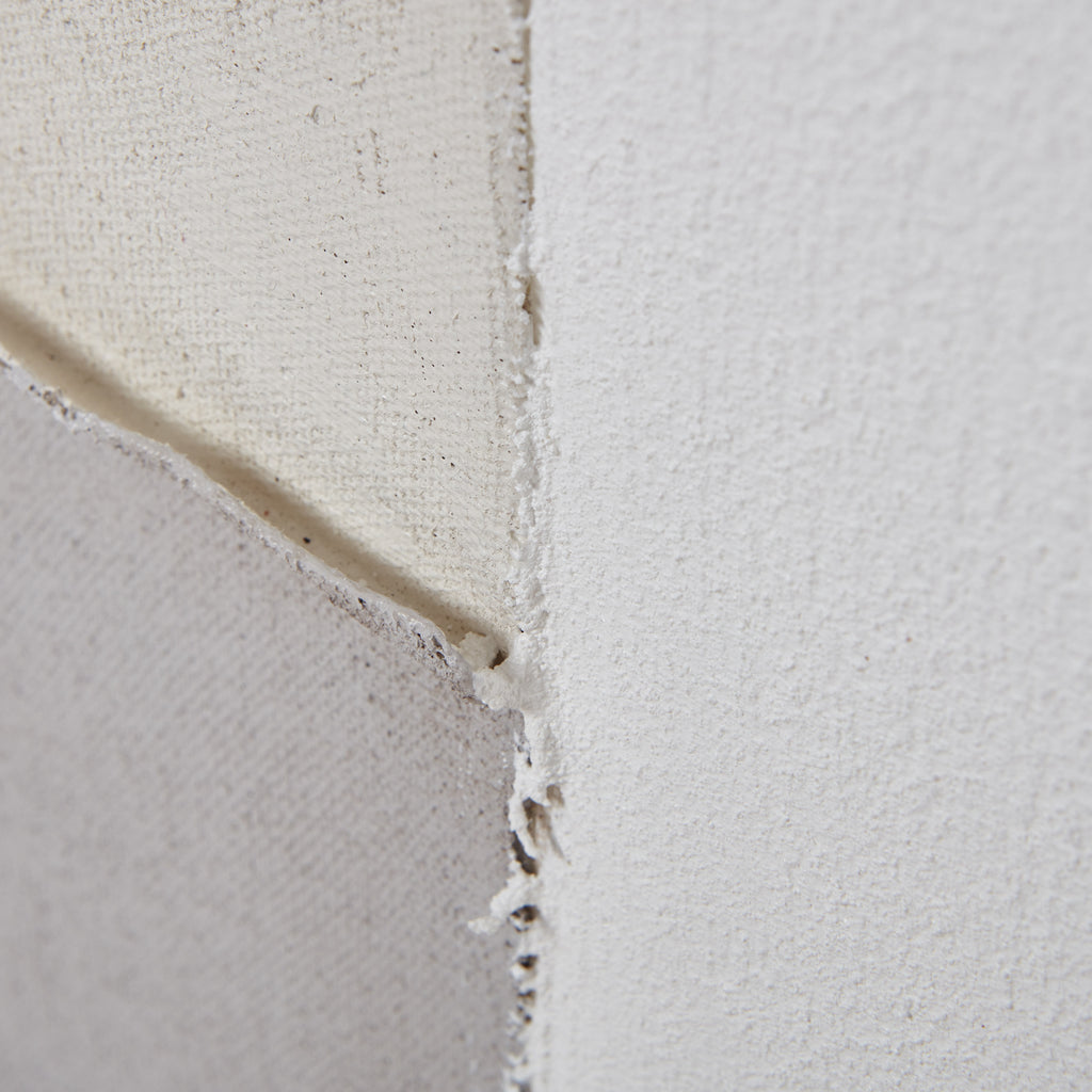 Detail of cream, off-white and grey painted sections meeting, showing fine surface texture and uneven overlapping edges.