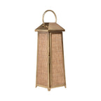 Three-quarter view of a tall tapered lantern with woven rattan panels, antique brass finish and curved handle.
