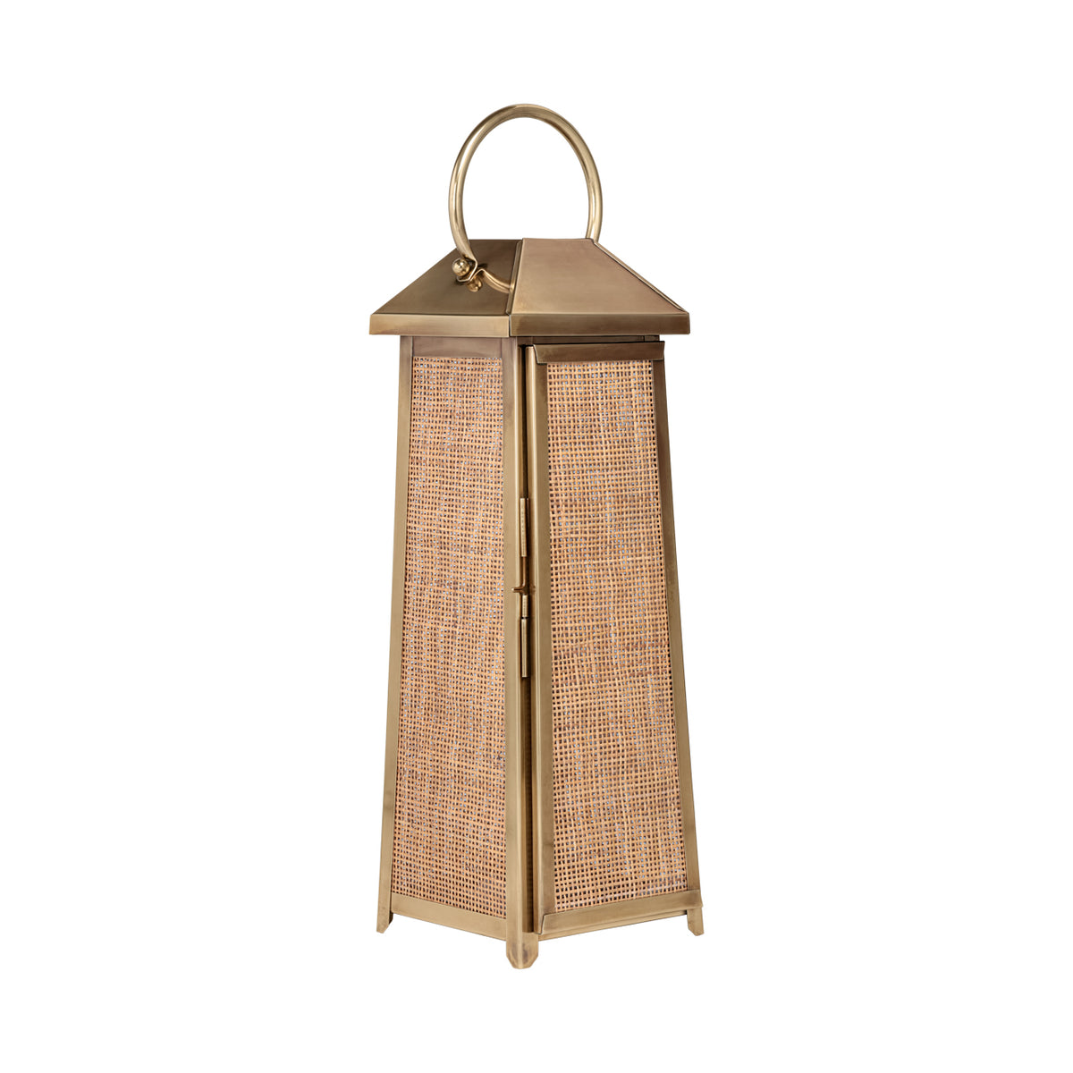 Three-quarter view of a tall tapered lantern with woven rattan panels, antique brass finish and curved handle.