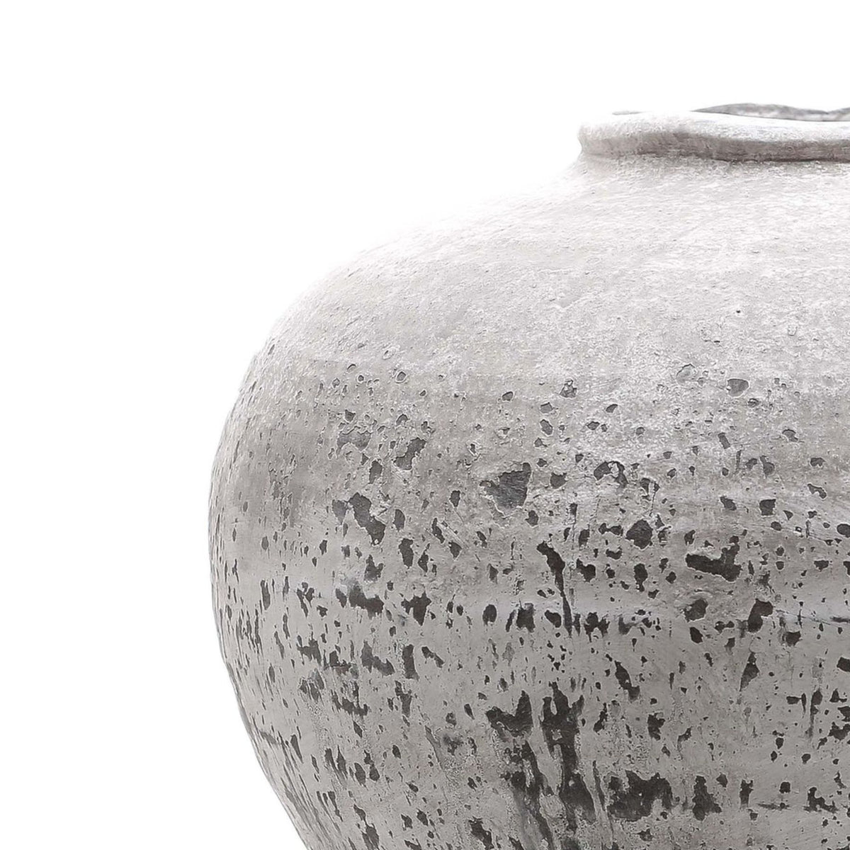 Close-up of the vase's rounded shoulder and irregular rim, showing the rough pale surface with dark speckles and streaks.