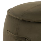 Close-up of the stool's green upholstery, stitched side handle, vertical seam and piping around the padded top.