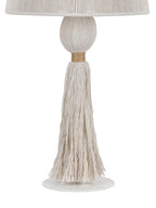 Detail of the lamp's rounded rope-wrapped stem, tan binding and long cream tassel hanging above the white metal foot.