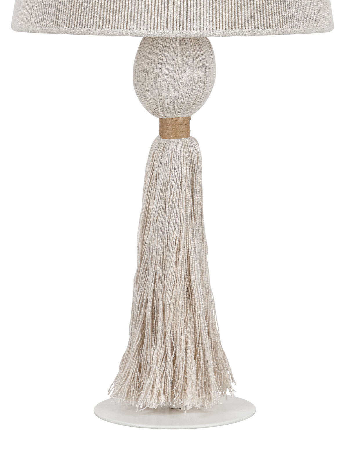Detail of the lamp's rounded rope-wrapped stem, tan binding and long cream tassel hanging above the white metal foot.