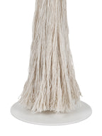 Close-up of loose cream tassel strands and their uneven ends above the lamp's smooth white circular foot.