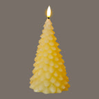 Tree-shaped LED candle photographed with a bright yellow-white flame-shaped tip against grey, showing its layered cream branch scales.