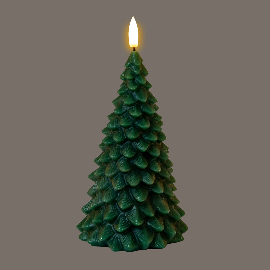Dark-green tree-form LED candle photographed with its flame-shaped tip glowing against a grey background.