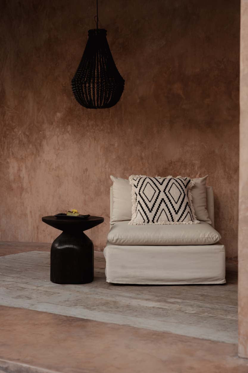 Teardrop Wooden Bead Chandelier – Black, Medium – styled above a lounge against a terracotta wall