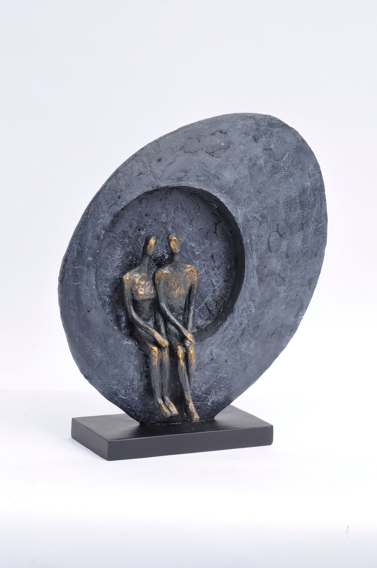 Accord Sculpture on a white background, showing two seated figures within a textured charcoal-grey surround on a black rectangular base.