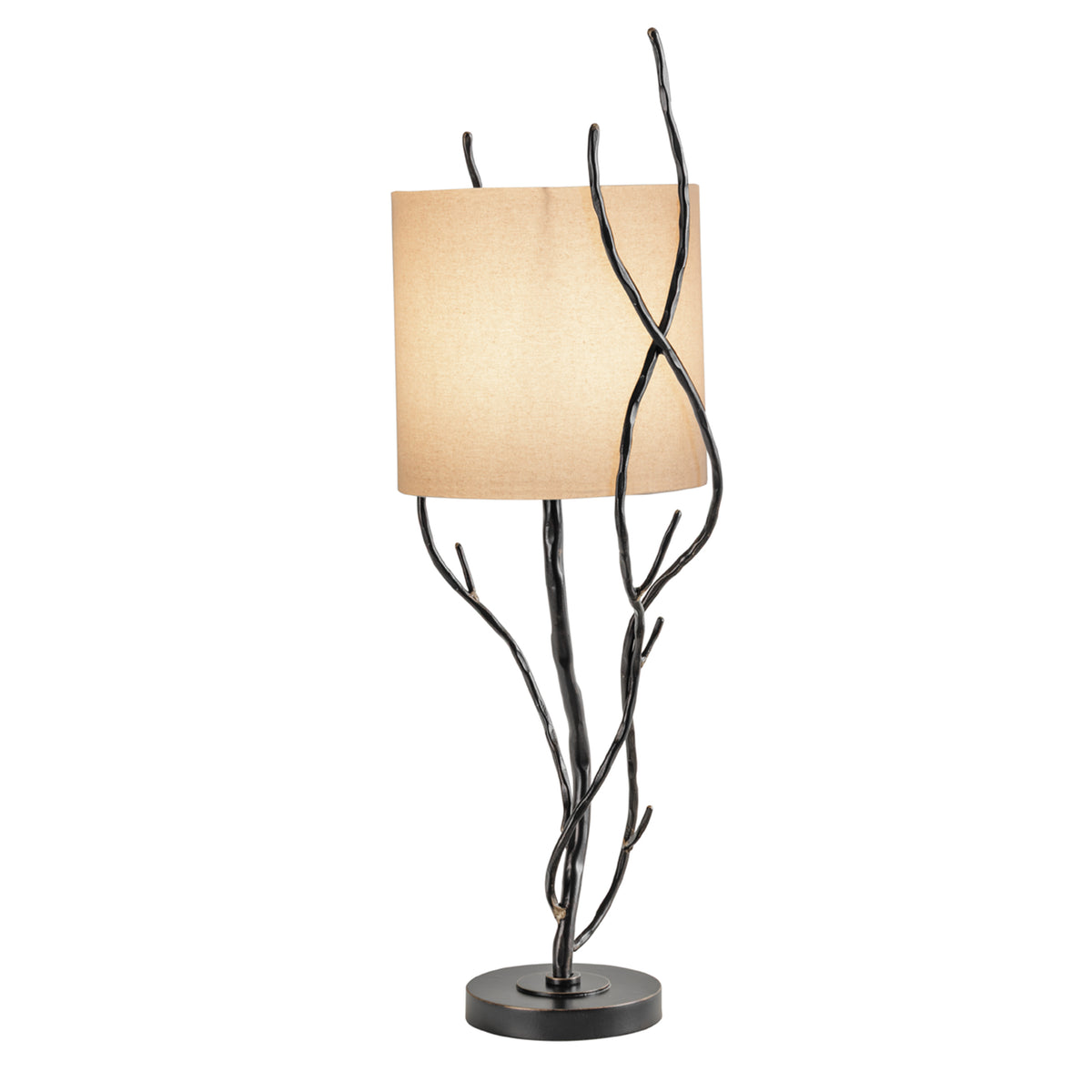 Thicket table lamp illuminated, with a warm glow through the linen shade behind crossing dark branches.