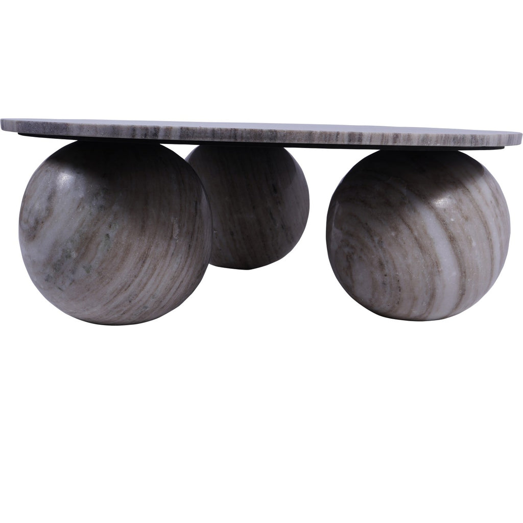 Low side view of the coffee table showing its slim marble top above three large spherical feet.