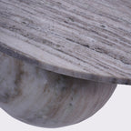 Close-up of the veined marble tabletop and curved edge above one rounded marble foot.