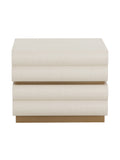 Front view of a pale, textured two-drawer nightstand with tiered drawer fronts, a gold-toned base and its top visible against a white background.