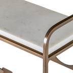 Close-up of the white marble top with faint markings beside the curved gold-toned side frame.