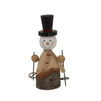 Front view of a smiling snowman decoration with a tall black top hat, red-striped scarf and ski poles beside a bark-covered base.