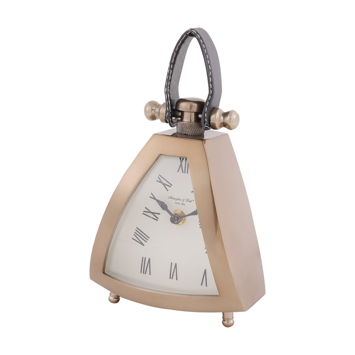 Three-quarter view of the small gold-toned Trigon clock, showing its flared triangular case, curved glass and black leather handle.