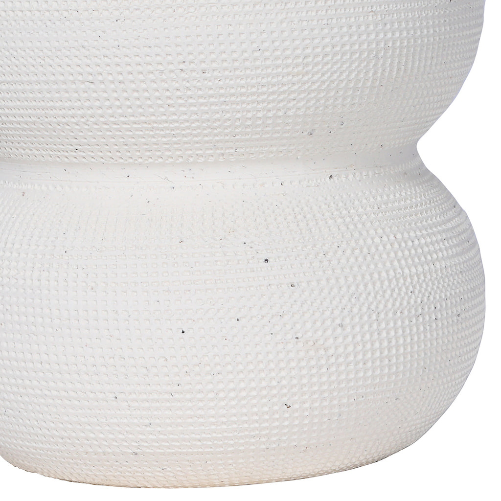 Detail of the vase's closely patterned white surface and narrow join between two rounded sections.